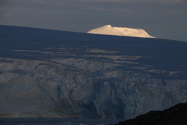 The peak of Mount Francais remains illuminated by the setting sun after the Marr Ice Piedmont the glacier covering much of Anvers Island has dropped into shadows Antarctic Peninsula  x