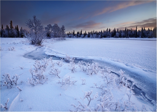The Umba River frozen and covered with snow Kola Peninsula Russia 
