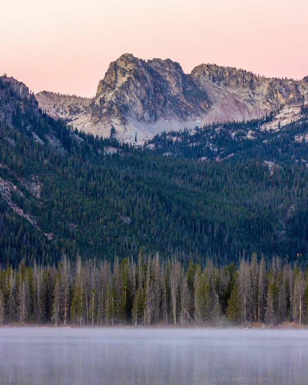 Theres something special about waking up early to watch the mist rise off the lake and see the soft pink sunrise at Stanley Lake Idaho 