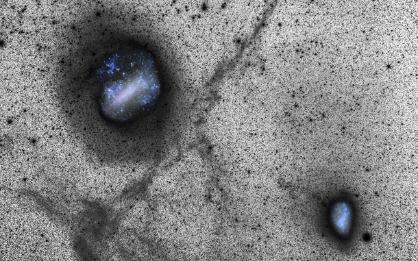 This deep view of the Large and Small Magellanic Clouds is actually a combination of two photos captured from ESOs La Silla Observatory The clouds are shown in color as glittering blue holes while the thousands of stars are captured in black and white