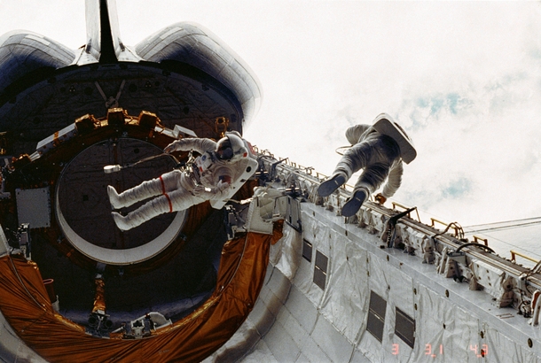 Today in  the first spacewalk of the shuttle program Astronauts Story Musgrave left and Don Peterson float in the cargo bay of the Earth-orbiting space shuttle Challenger during their April   spacewalk on the STS- mission 