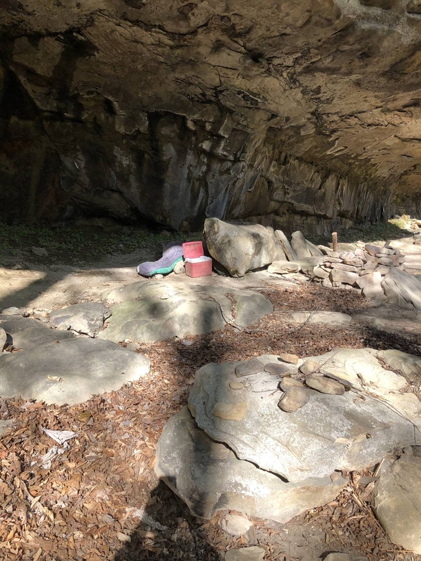 Unsettling abandoned campsite found under a cliff face Someone left behind all their gear their boots and even a message burned into the rocks Album in comments
