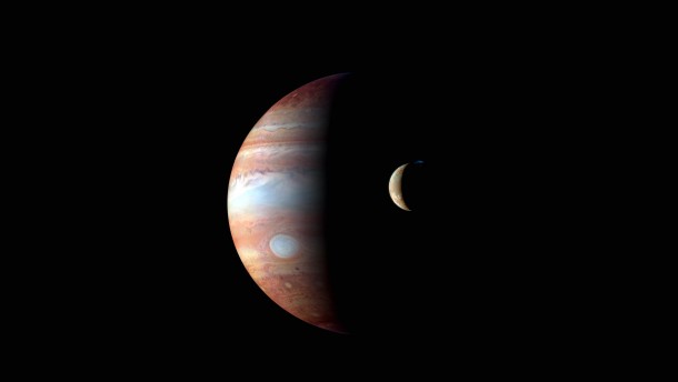 Volcano erupts on Io with Jupiter in the background 