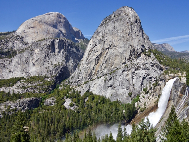 With tall barren rock peaks clear skies and a waterfall so bursting it creates a rainbow youd be excused to think that Yosemite is from some fantasy universe 