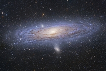 A beautiful picture of the Andromeda Galaxy showing its bright yellow nucleus dark winding dust lanes gorgeous blue spiral arms and star clusters 