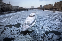 A boat navigates the icy river Moskva or Moscow River in Moscow Russia Alexander Zemlianichenko 