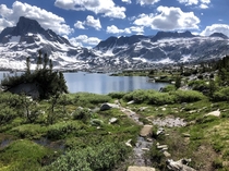 A bright and sunny summer day in California among snow-capped peaks lush meadows and a pristine alpine lake From an outing in July  