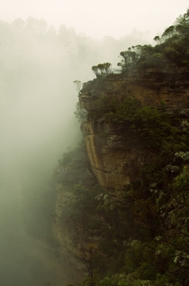 A cliff looming through the mists of Wentworth Falls Australia 