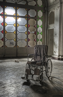 A decaying wheelchair sits in an abandoned asylum in Italy By Dan Raven on Flickr 