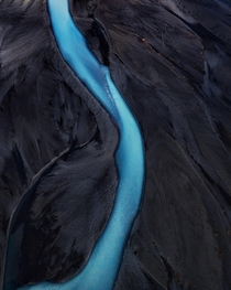 A glacial river pierces through the black sand in Southern Iceland 