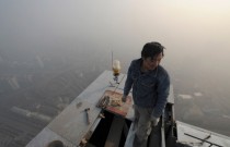 A laborer works atop a building in Hefei on a hazy day Anhui province China Jan   