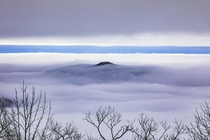 A mountain peak nearly covered by clouds looking out from the Blue Ridge Overlook inside Black Rock Mountain State Park in Northeast Georgia 