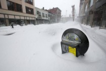 A parking meter pokes out of a snow bank during a blizzard in Portland Maine 