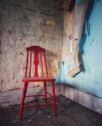 A red chair left behind in an old farmhouse