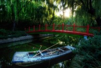 A small red bridge in the Forbidden City with boat 