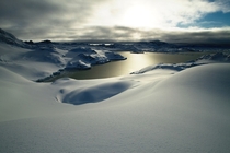 A soft layer of untouched snow next to the frozen sea on Kulusuk Island by eastern Greenland 