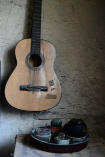 A table and a guitar in an abandoned house 