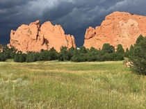 A thunderstorm approaches the sunlit sandstone of the Garden of the Gods in Colorado 