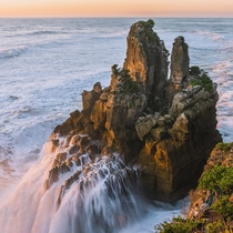 A Wave Crashing Over Some Rocks At Sunset in West Coast New Zealand 