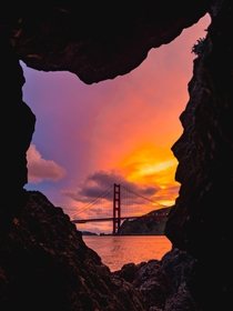 A window to a Gate The Golden Gate Bridge seen from between sea rocks 