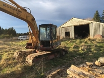 Abandoned Excavator By Shed In New Zealand