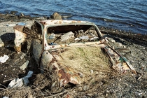An abandoned car at low tide 