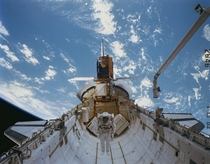 An astronaut floats in Space Shuttle Challengers payload bay on mission STS--C after a successful repair of the Solar Max satellite 