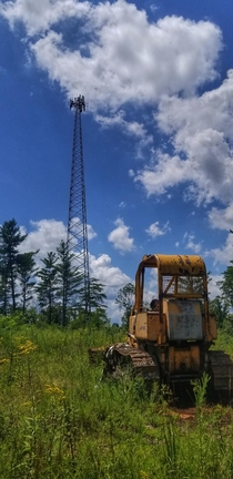 An old bulldozer abandoned after clearing the way for the construction of this tower