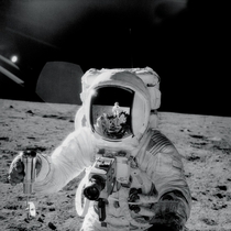 Apollo  astronaut Alan Bean holds a special environmental sample container filled with lunar soil collected during his sojourn on the lunar surface A Hasselblad camera is mounted on the chest of his spacesuit Pete Conrad who took this image is reflected i