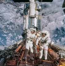 Astronauts John M Grunsfeld right and Richard M Linnehan STS- payload commander and mission specialist respectively are photographed near the giant Hubble Space Telescope temporarily hosted in the Space Shuttle Columbias cargo bay