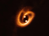 Astronomers spot two baby stars locked in a gravitational waltz thats twisting their planet-forming disks into a pretzel-shaped knot