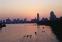 Boston rowing down the Charles River at dusk