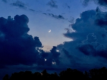 Crescent moon between the thunderheads