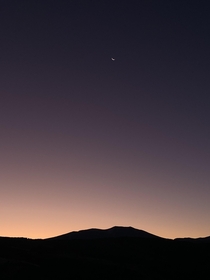 Crescent moon lingers over the rising sun Rocky Mountains Idaho 
