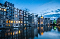 Damrak Amsterdam reflected in the water  Photographed by Simon van Ooijen