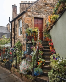 Entrance to a stone cottage adorned with flowers in Stockbridge Edinburgh Scotland