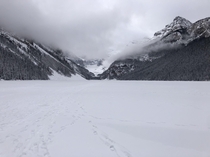 Fog rolling in over a frozen solid Lake Louise - Alberta Canada 