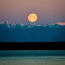 Full moon setting at sunrise seen from Seattle 
