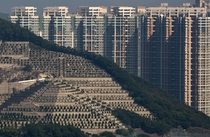 Graves cover a hillside in front of high-rise buildings in Hong Kong