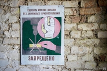 It is forbidden to drill small items without clamping device A Soviet-era hand-painted warning sign in an abandoned harvester depot in the Chernobyl Zone 