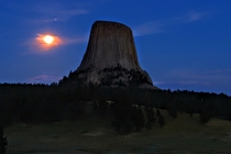 Jupiter Saturn and the full moon rising over Devils Tower Wyoming USA 