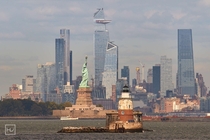 Lady Liberty and Robbins Reef lighthouse in front of Hudson Yards NYC 