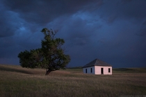 Little house on the prairie illuminated by lightning in rural Nebraska 
