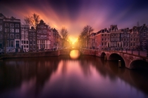 Long-exposure of the setting sun over the canals of Amsterdam  by Ivn Maigua