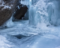 Looking into a cave that houses a frozen waterfall Natural Bridge in Yoho National Park 