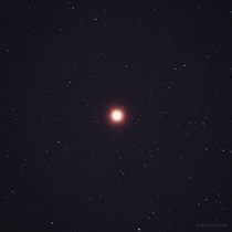 Mars shining bright in front of a field of stars 