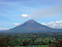 Mount Sinabung in Sumatra Indonesia with villages in the foreground 