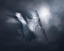 Mountain peeking through some heavy clouds in Nordfjordeid Norway 