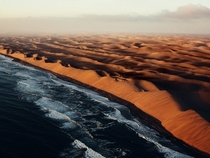 Namibia on Africas southwest coast is a large country with a harsh landscape The towering and constantly shifting dunes of the Namib Desert shown here in this aerial photo by Julian Walter run right to the Atlantic Ocean and can reach up to a thousand fee