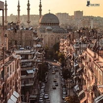 Narrow streets in Aleppo syria pictured in the photo is the cathedral of saint georgios and the minarets of the tawhid mosque